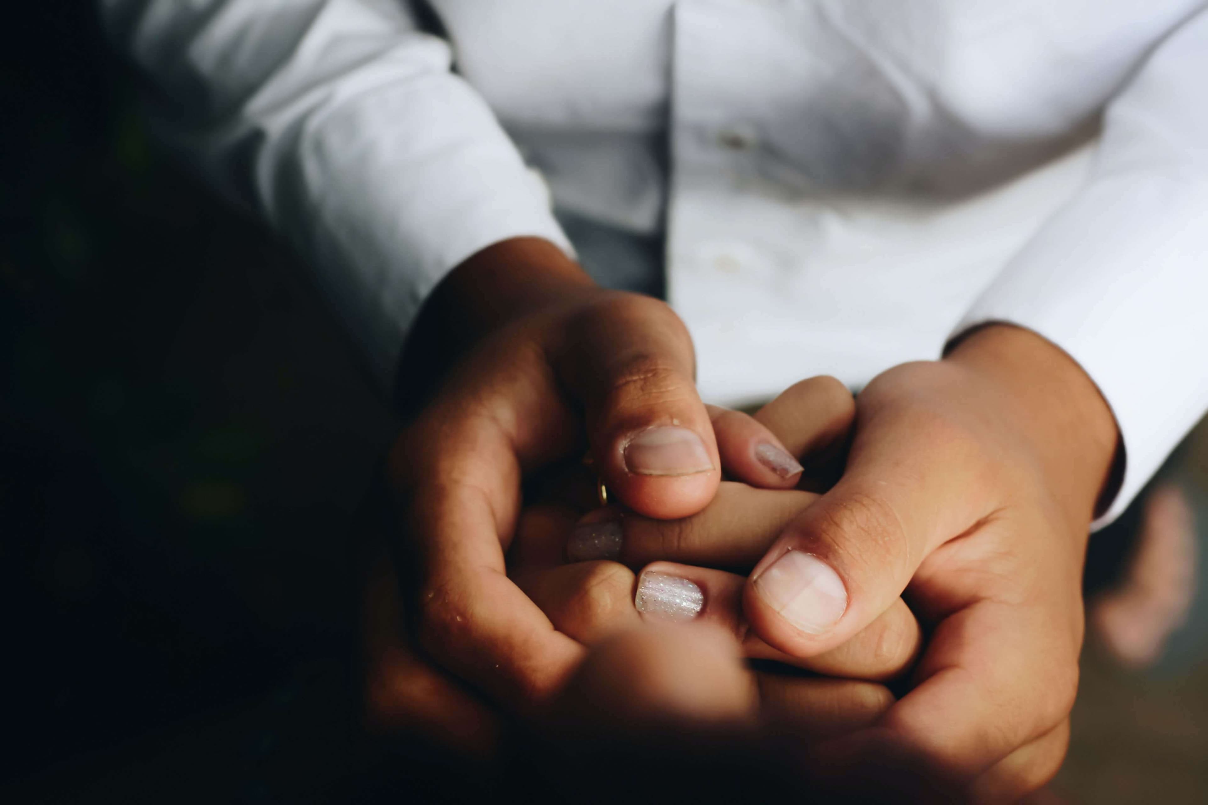 Two people embracing each other's hands.